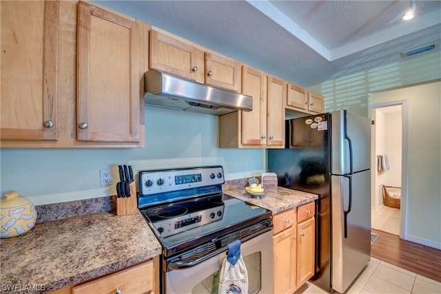 kitchen featuring light tile flooring, light brown cabinetry, light stone counters, and stainless steel range with electric stovetop