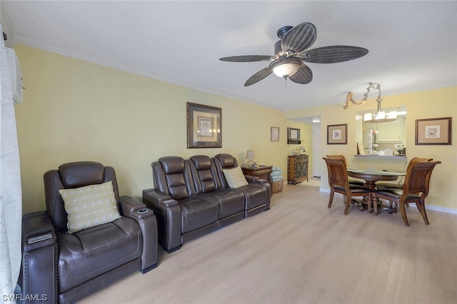 living room with crown molding, light hardwood / wood-style flooring, and ceiling fan with notable chandelier