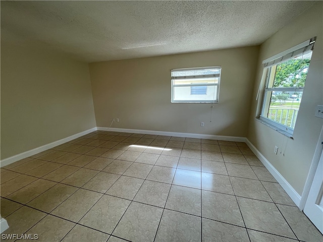 tiled empty room with a textured ceiling