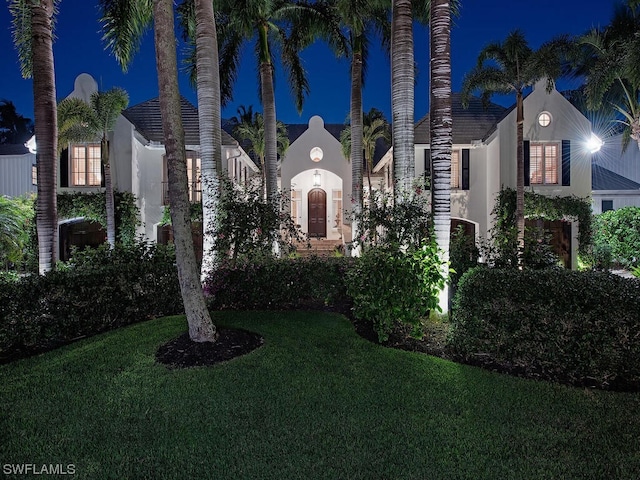 view of front of house featuring central AC unit and a yard