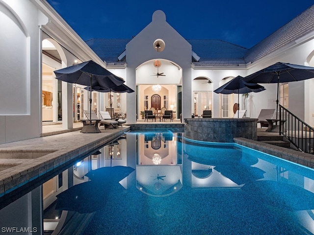 pool at twilight featuring a patio area