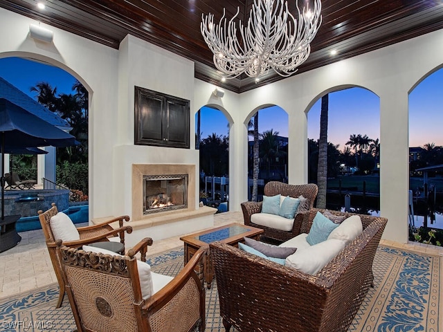 patio terrace at dusk with an outdoor living space with a fireplace and an outdoor hot tub