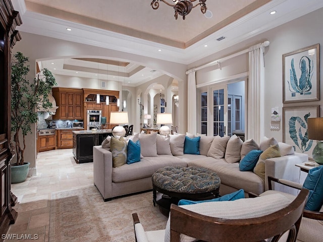 tiled living room featuring a raised ceiling, ornamental molding, and french doors