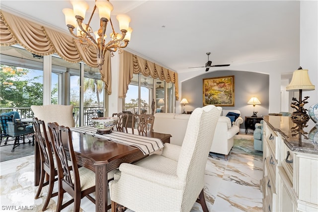 dining space with crown molding and ceiling fan with notable chandelier