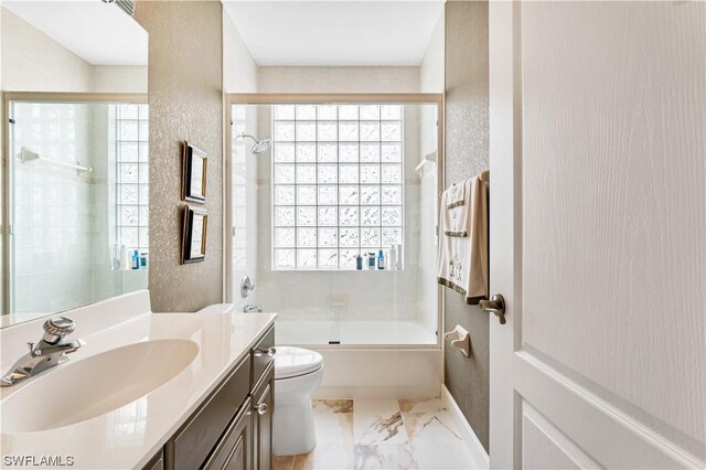 full bathroom featuring vanity, toilet, and combined bath / shower with glass door