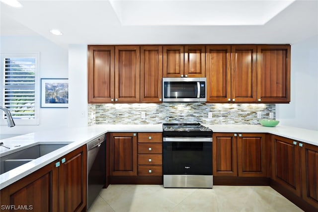 kitchen with sink, tasteful backsplash, light tile flooring, and stainless steel appliances