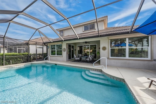 view of swimming pool with a lanai, ceiling fan, and a patio