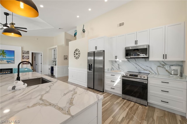 kitchen with white cabinetry, tasteful backsplash, stainless steel appliances, and ceiling fan