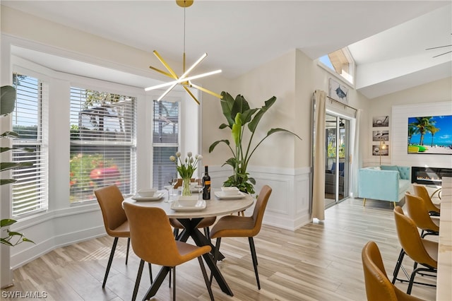 dining space featuring lofted ceiling, a chandelier, and light wood-type flooring