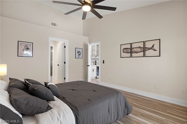 bedroom featuring light hardwood / wood-style floors, connected bathroom, and ceiling fan