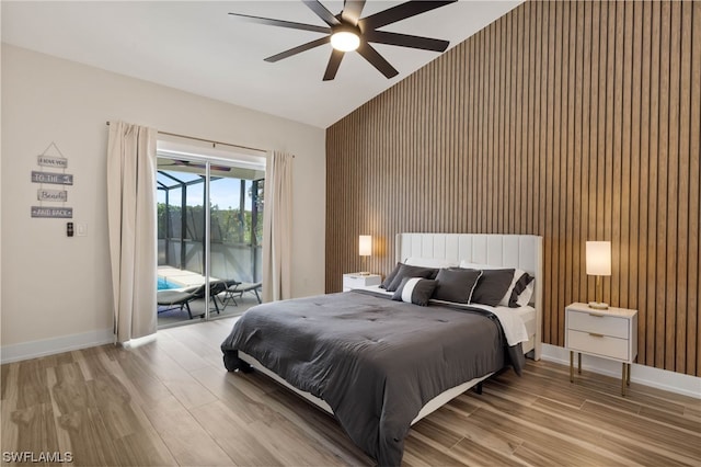 bedroom featuring access to exterior, vaulted ceiling, light hardwood / wood-style floors, and ceiling fan