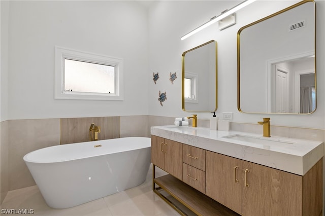 bathroom featuring double sink, tile walls, a washtub, tile floors, and vanity with extensive cabinet space