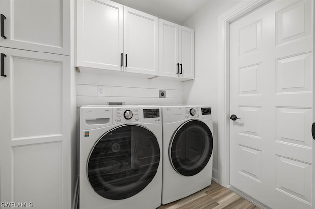 laundry room featuring washer and clothes dryer, cabinets, and hookup for an electric dryer