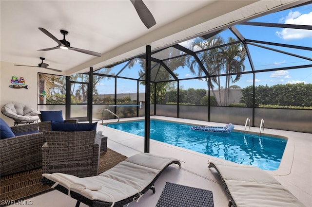 view of pool with outdoor lounge area, a patio, ceiling fan, and glass enclosure