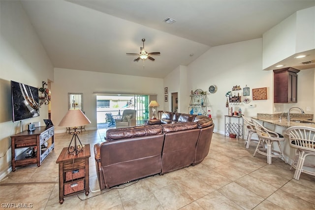 tiled living room featuring ceiling fan, lofted ceiling, and sink