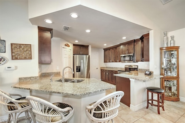 kitchen featuring a breakfast bar, sink, kitchen peninsula, and stainless steel appliances