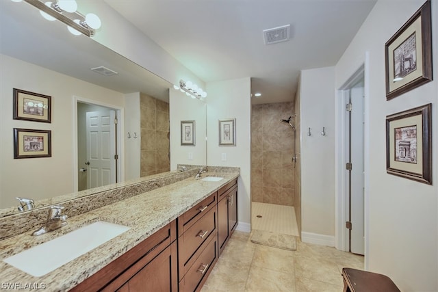 bathroom featuring tile patterned floors, vanity, and tiled shower