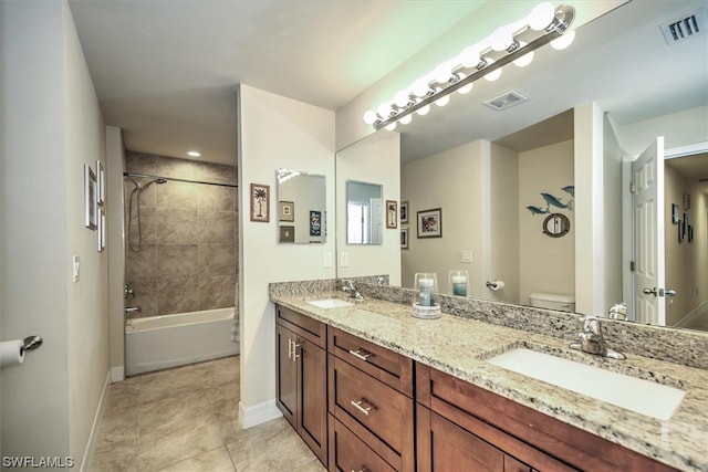 full bathroom featuring tile patterned flooring, vanity, toilet, and tiled shower / bath