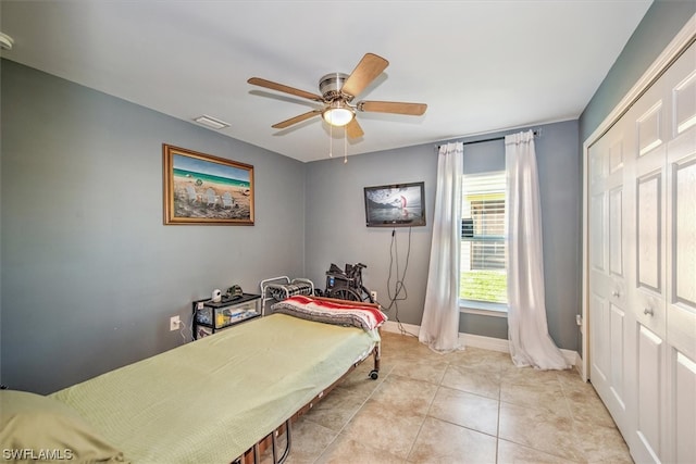 tiled bedroom featuring ceiling fan and a closet