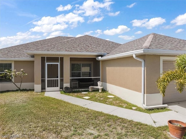 back of house featuring a garage and a yard