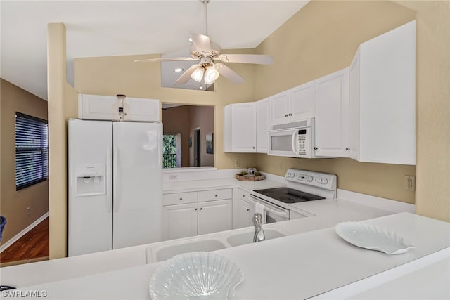 kitchen featuring white appliances, white cabinets, dark wood-type flooring, and vaulted ceiling