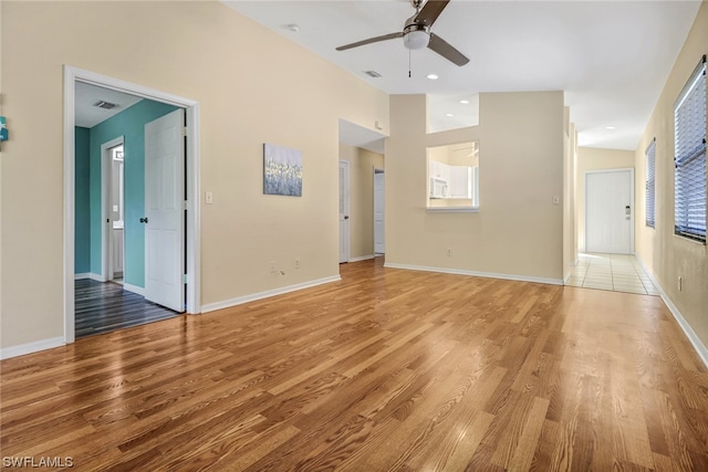 unfurnished living room with light tile flooring and ceiling fan