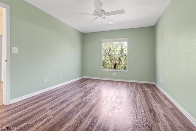 spare room with dark hardwood / wood-style floors and ceiling fan