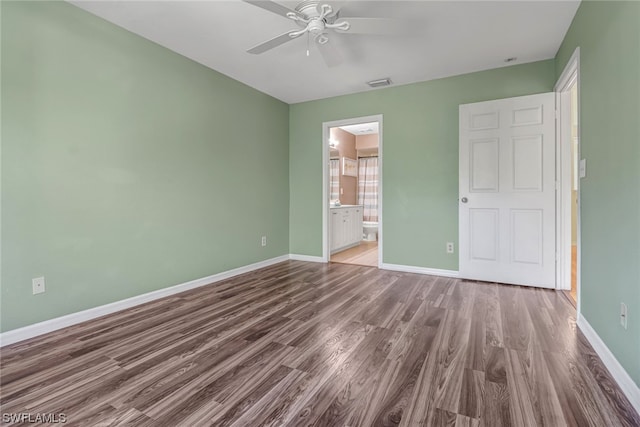 unfurnished bedroom with dark hardwood / wood-style floors, ceiling fan, and ensuite bath