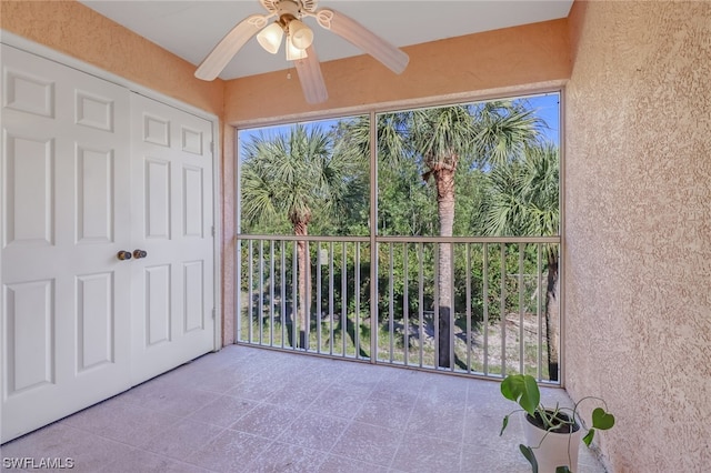 unfurnished sunroom with ceiling fan