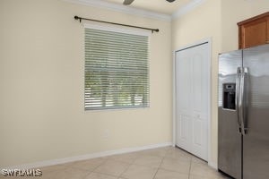 interior space featuring ceiling fan, crown molding, and light tile patterned floors