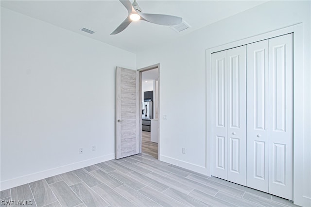 unfurnished bedroom with light hardwood / wood-style floors, a closet, and ceiling fan