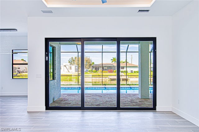 entryway featuring a raised ceiling and light wood-type flooring