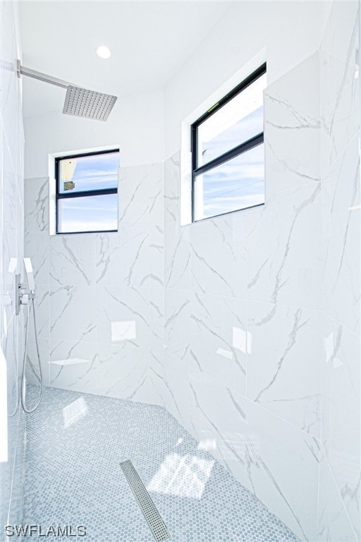 bathroom with plenty of natural light and tiled shower