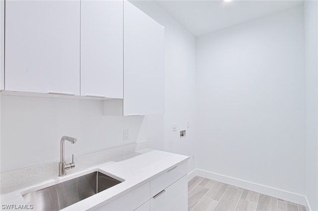 interior space with light hardwood / wood-style flooring, cabinets, and sink