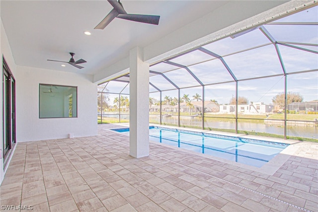 view of pool featuring a water view, a patio, ceiling fan, and glass enclosure