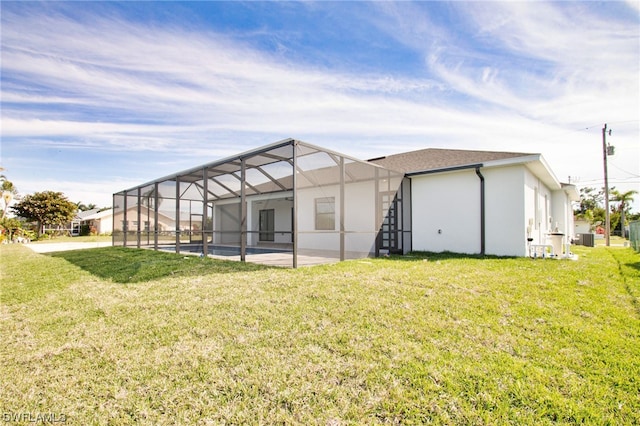 rear view of house featuring a yard, a pool, and glass enclosure