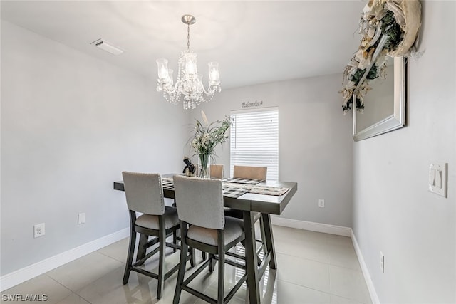 tiled dining room with an inviting chandelier