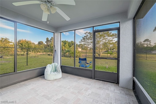 sunroom / solarium featuring ceiling fan