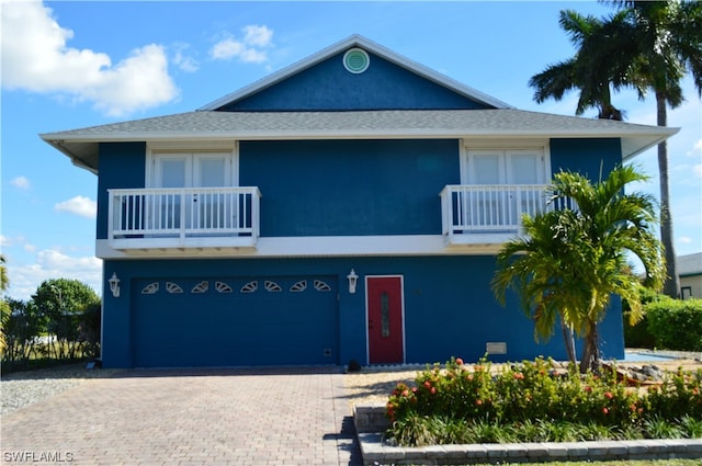 view of front of home featuring a balcony and a garage