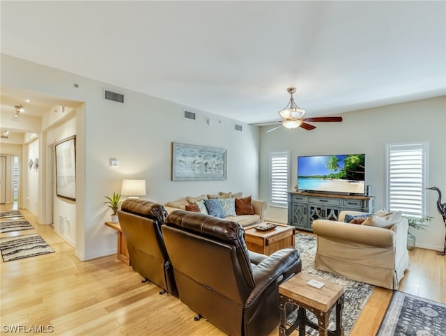 living room with ceiling fan and light wood-type flooring