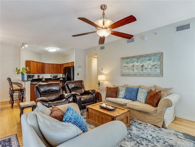 living room with light hardwood / wood-style floors and ceiling fan