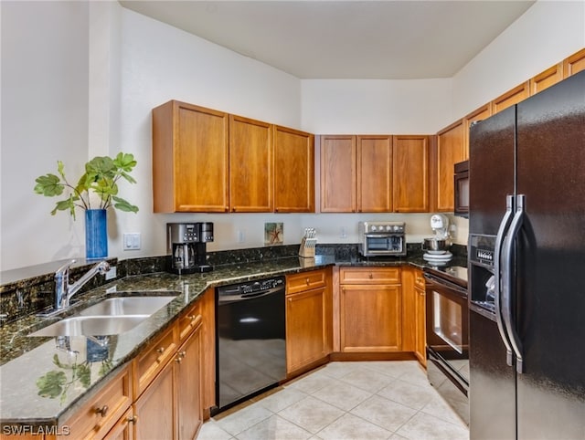 kitchen with dark stone counters, black appliances, sink, and light tile flooring