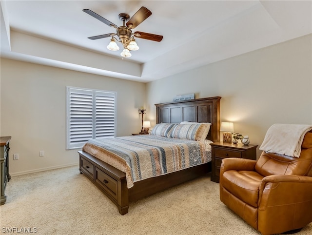 bedroom with a tray ceiling, ceiling fan, and light colored carpet