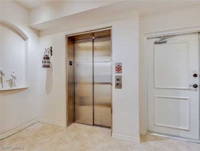 interior space with a closet, light tile floors, and elevator