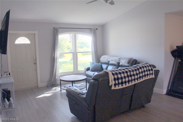 living room featuring lofted ceiling, ceiling fan, and light wood-type flooring