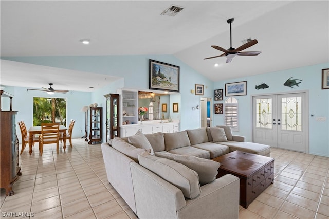 tiled living room featuring lofted ceiling, french doors, and ceiling fan