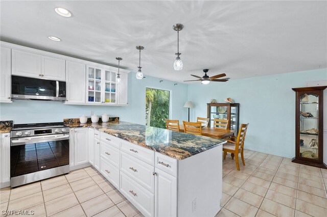 kitchen featuring appliances with stainless steel finishes, dark stone countertops, white cabinets, hanging light fixtures, and kitchen peninsula