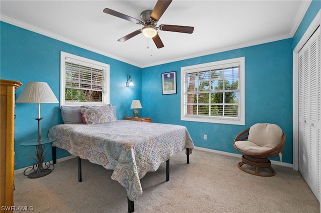 bedroom with light carpet, crown molding, a closet, and ceiling fan