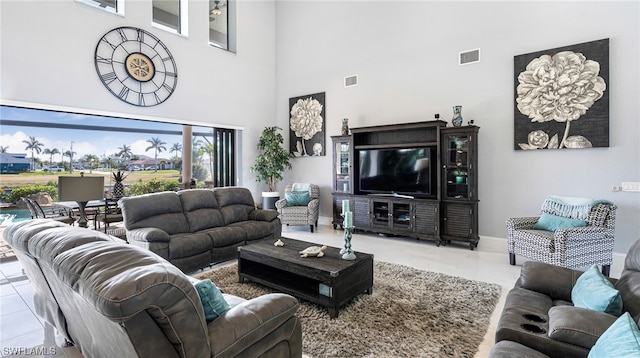 living room featuring light tile floors and a towering ceiling