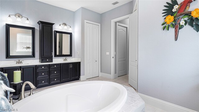 bathroom with double vanity and a bath